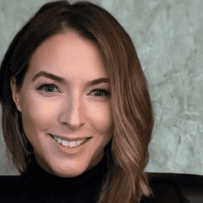 Smiling woman with brown hair against gray background